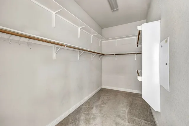a view of walk in closet with empty racks