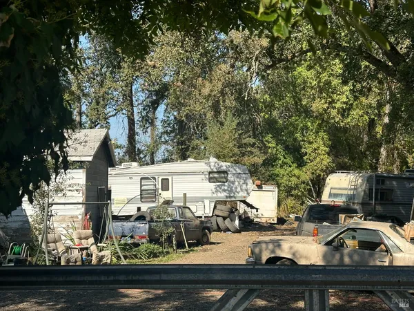 a view of multiple houses with cars parked on the road