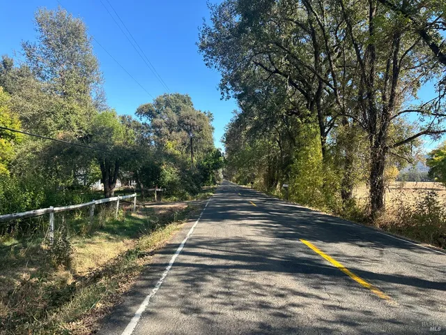 a view of a yard with wooden fence