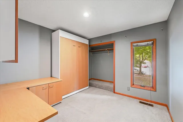 an empty room with windows and closet