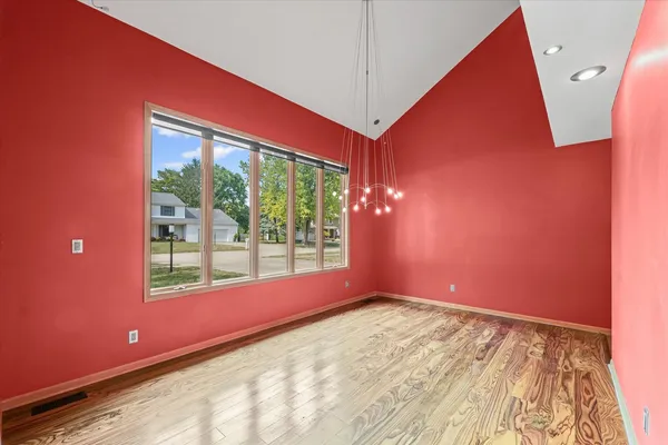 a view of empty room with wooden floor