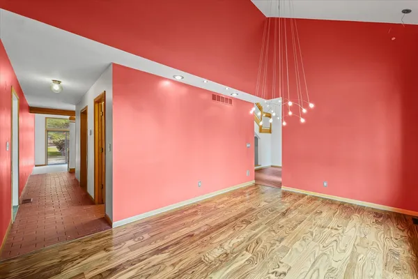 a view of a hallway with wooden floor and staircase