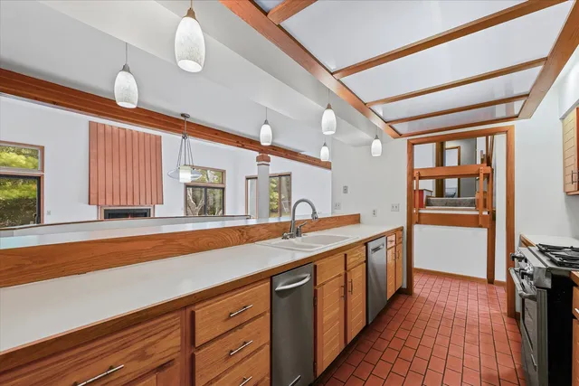 a kitchen with stainless steel appliances granite countertop a sink and dishwasher a stove with wooden floor