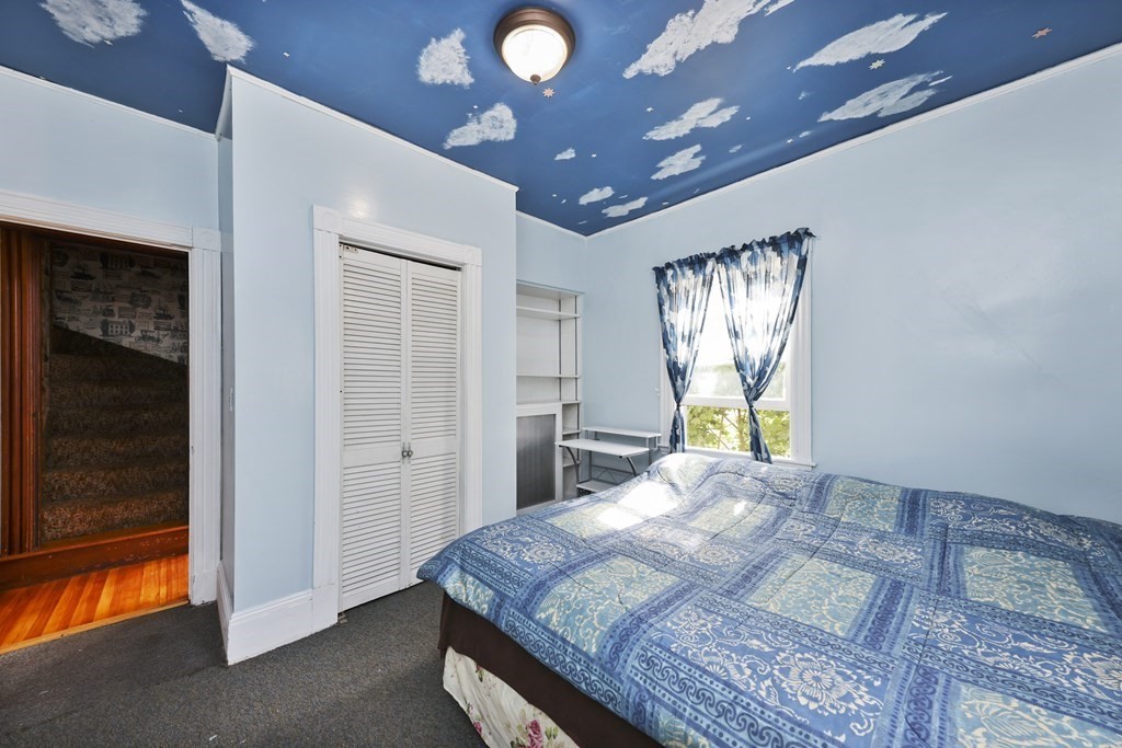 60 Baker Road Everett, MA 02149 - Photo 12 of 27 a bedroom with a bed and a chandelier