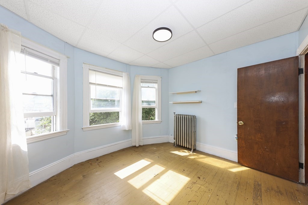 60 Baker Road Everett, MA 02149 - Photo 14 of 27 a view of an empty room with a window and a kitchen