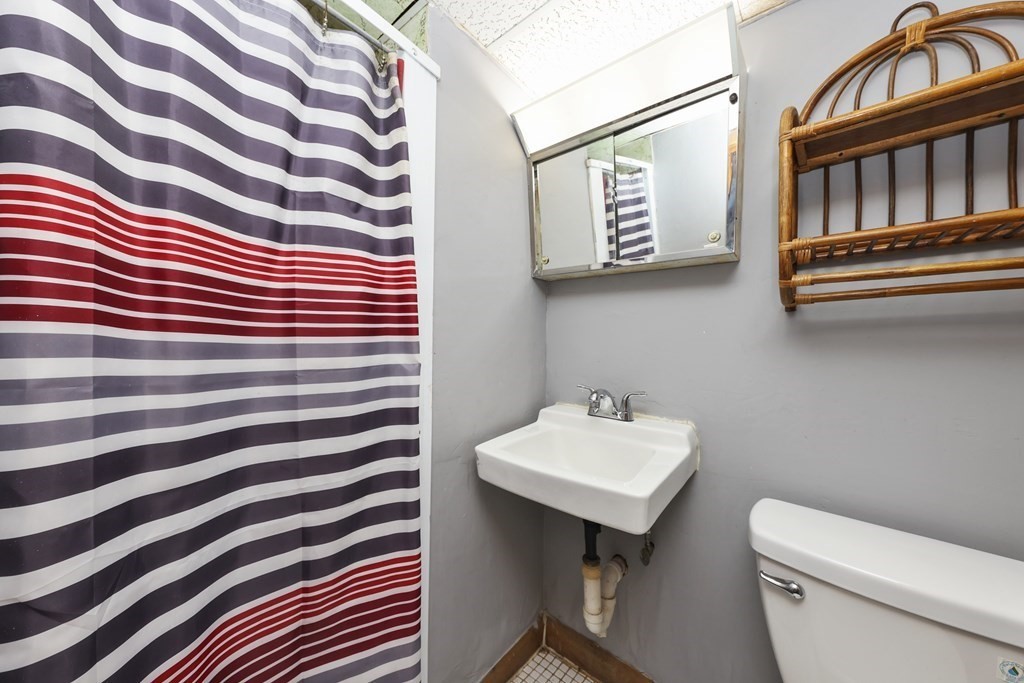 60 Baker Road Everett, MA 02149 - Photo 21 of 27 a bathroom with a sink a mirror and a toilet