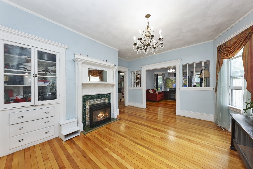 60 Baker Road Everett, MA 02149 - Photo 7 of 27 a view of a livingroom with furniture a fireplace wooden floor and windows