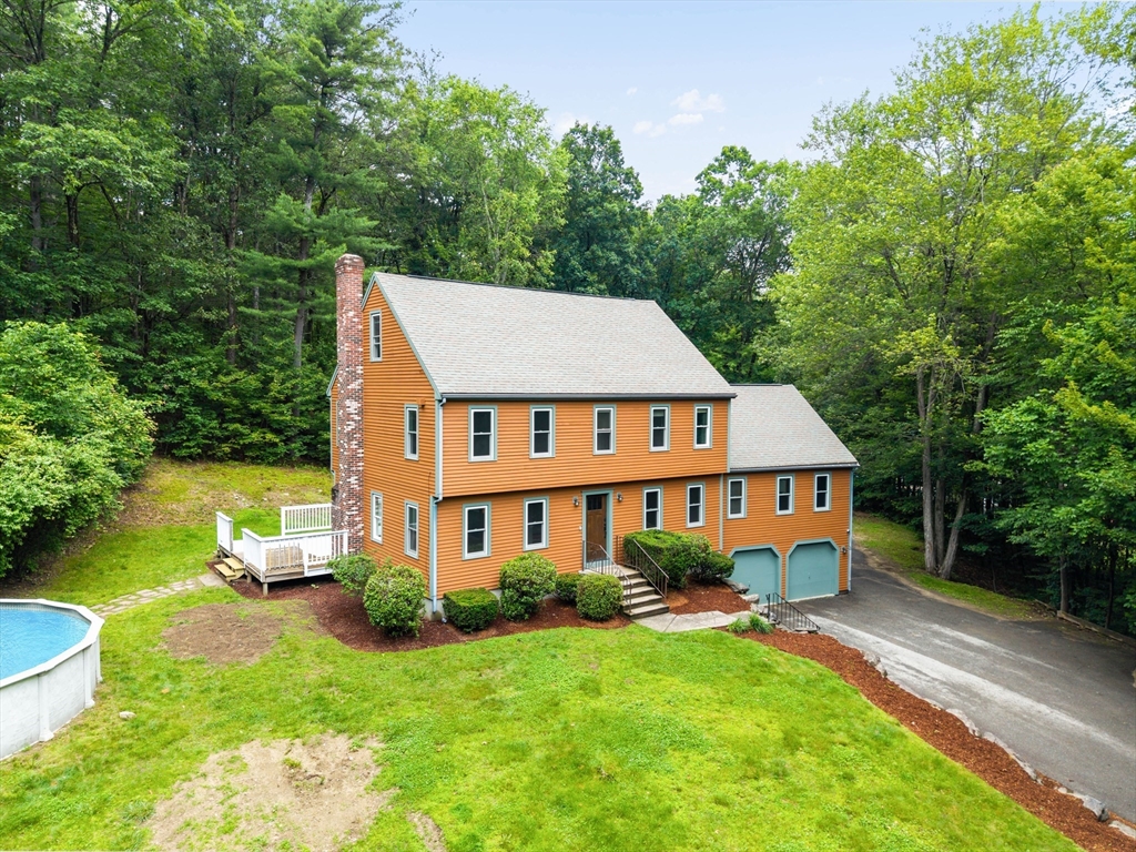 an aerial view of a house with swimming pool garden view and trees