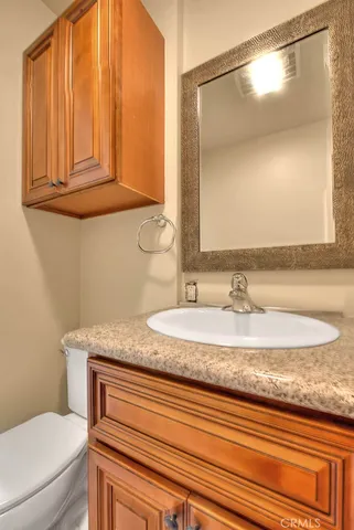 a bathroom with a granite countertop sink and a mirror