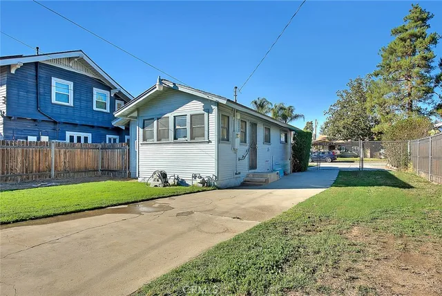 a view of a backyard with a large tree and wooden fence