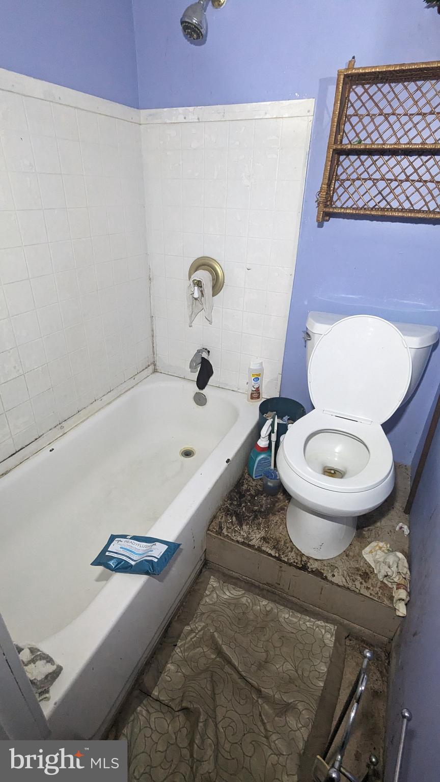 6740 Solomons Island Road North Owings, MD 20736 - Photo 35 of 58 a bathroom with a granite countertop toilet and a bathtub