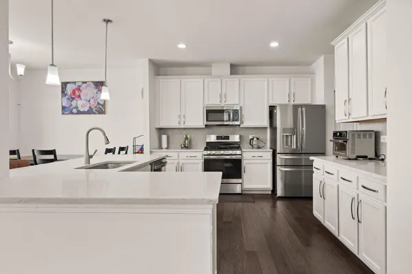 a kitchen with kitchen island a white cabinets and stainless steel appliances