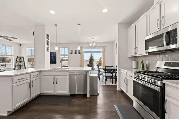 a kitchen with stainless steel appliances a sink a stove a microwave a center island and cabinets