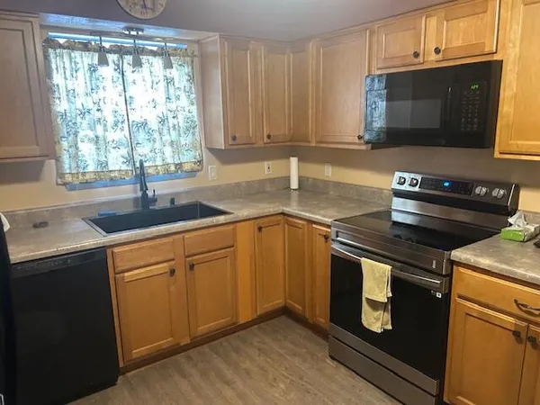 a kitchen with granite countertop a sink stainless steel appliances and cabinets
