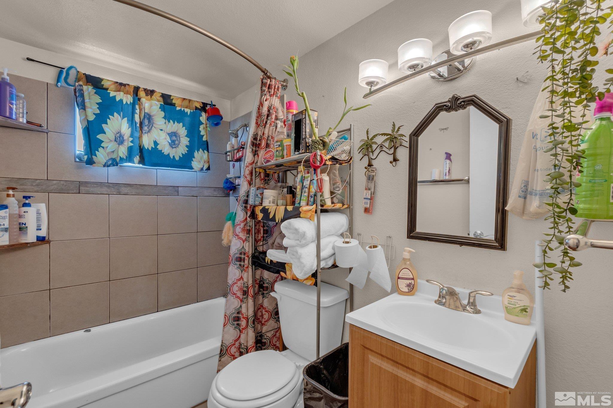 2265 Mannington Street Reno, NV 89512 - Photo 14 of 25 a bathroom with a sink a mirror a toilet and a bathtub