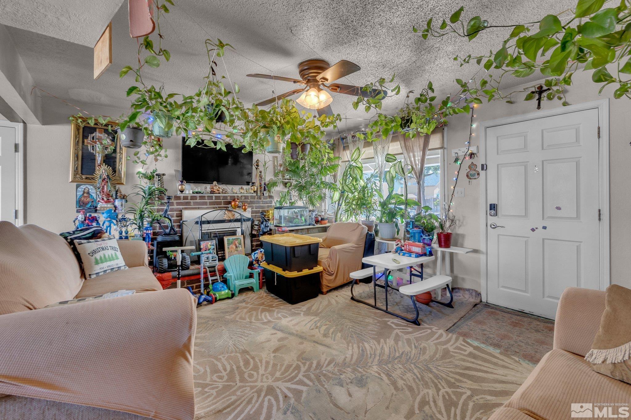 2265 Mannington Street Reno, NV 89512 - Photo 5 of 25 a living room with furniture a flat screen tv and a fireplace
