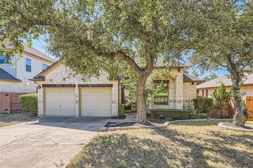 290 Maeves Way Austin, TX 78737 - Photo 1 of 13 Mature trees shade this inviting single-story residence, featuring a stone facade and an attached double garage.
