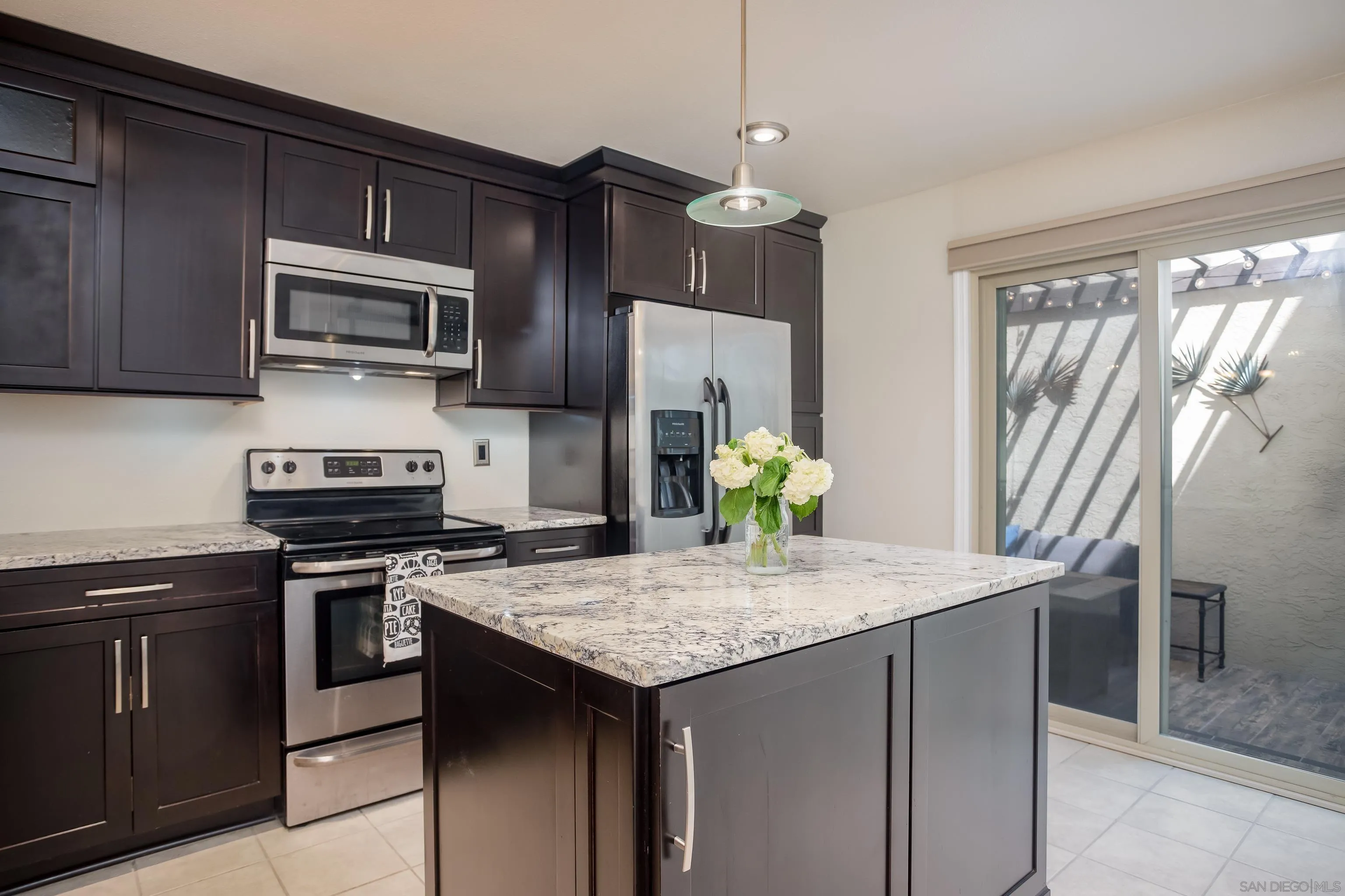 6345 Rancho Mission Road, Unit 3 San Diego, CA 92108 - Photo 13 of 43 a kitchen with granite countertop stainless steel appliances a stove microwave and refrigerator