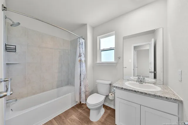 a bathroom with a granite countertop toilet a sink and a bathtub