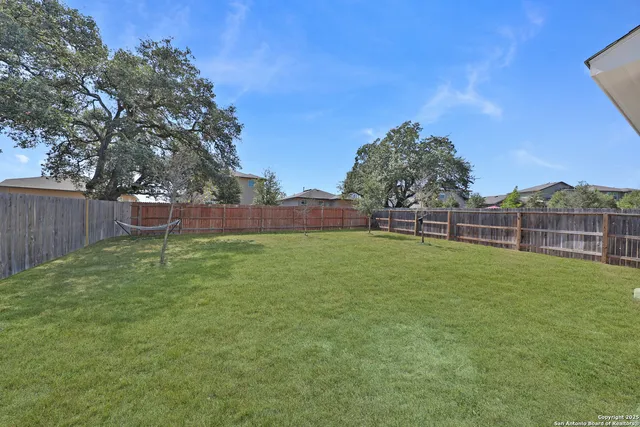 a view of a backyard with grass and trees