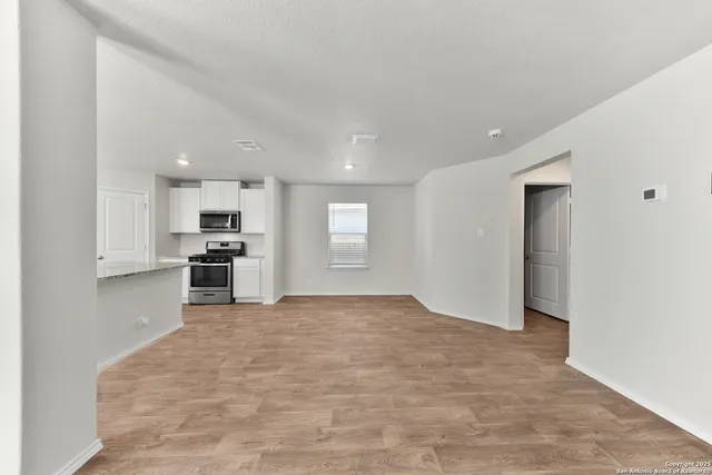 a view of kitchen with stainless steel appliances refrigerator and window