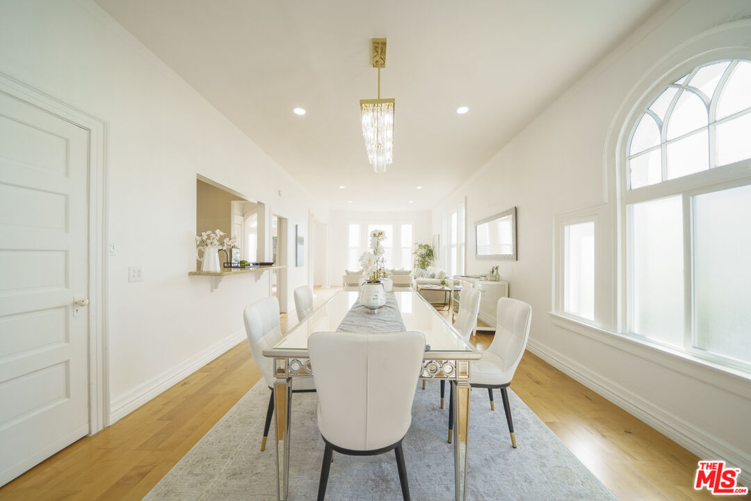 1159 South Norton Avenue Los Angeles, CA 90019 - Photo 15 of 39 a dining room with furniture a chandelier and wooden floor