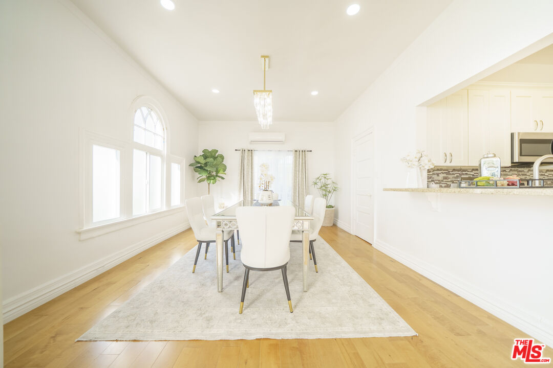 1159 South Norton Avenue Los Angeles, CA 90019 - Photo 16 of 39 a living room with a dining table and a rug