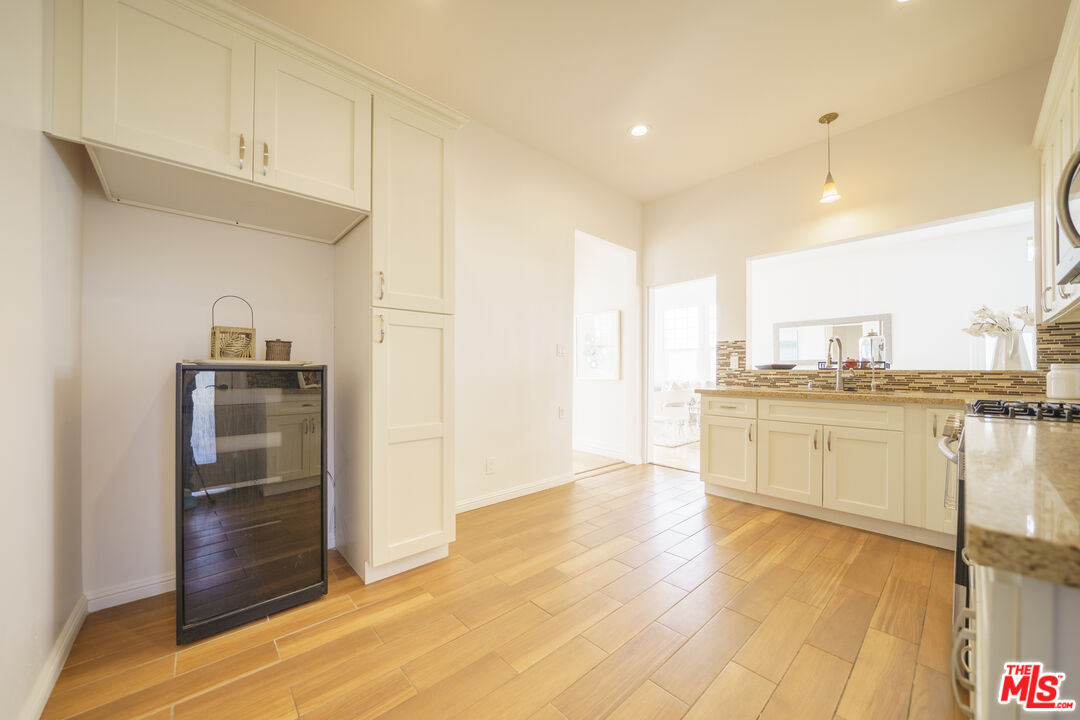 1159 South Norton Avenue Los Angeles, CA 90019 - Photo 19 of 39 a view of a kitchen with kitchen island white cabinets and wooden floor