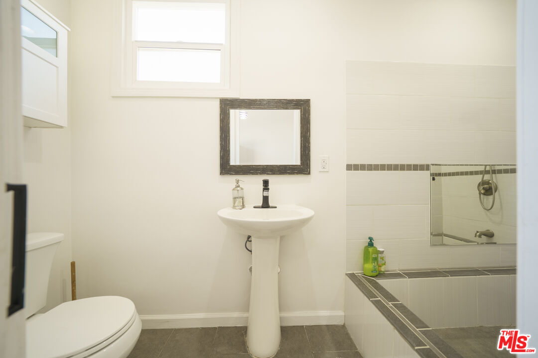 1159 South Norton Avenue Los Angeles, CA 90019 - Photo 22 of 39 a bathroom with a sink a toilet and shower