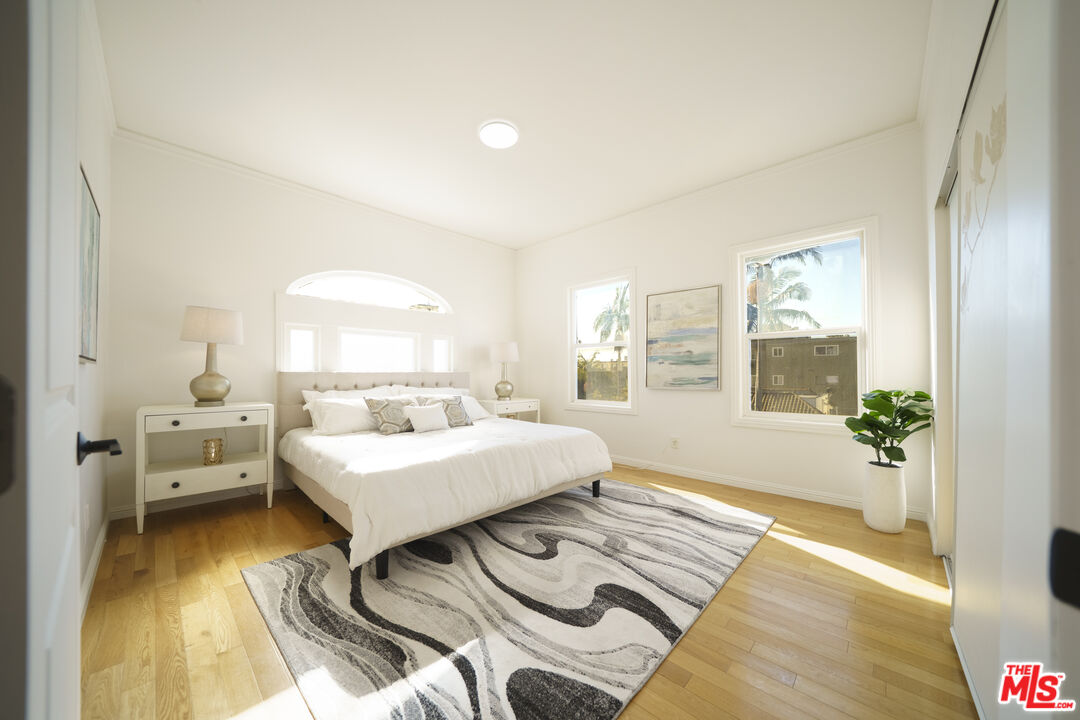 1159 South Norton Avenue Los Angeles, CA 90019 - Photo 27 of 39 a bedroom with a bed and wooden floor