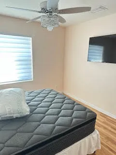 a bed sitting in a bedroom next to a window and a chandelier