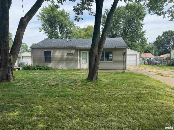 a front view of house with yard and trees around