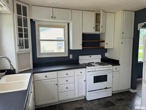 a kitchen with white cabinets and white appliances