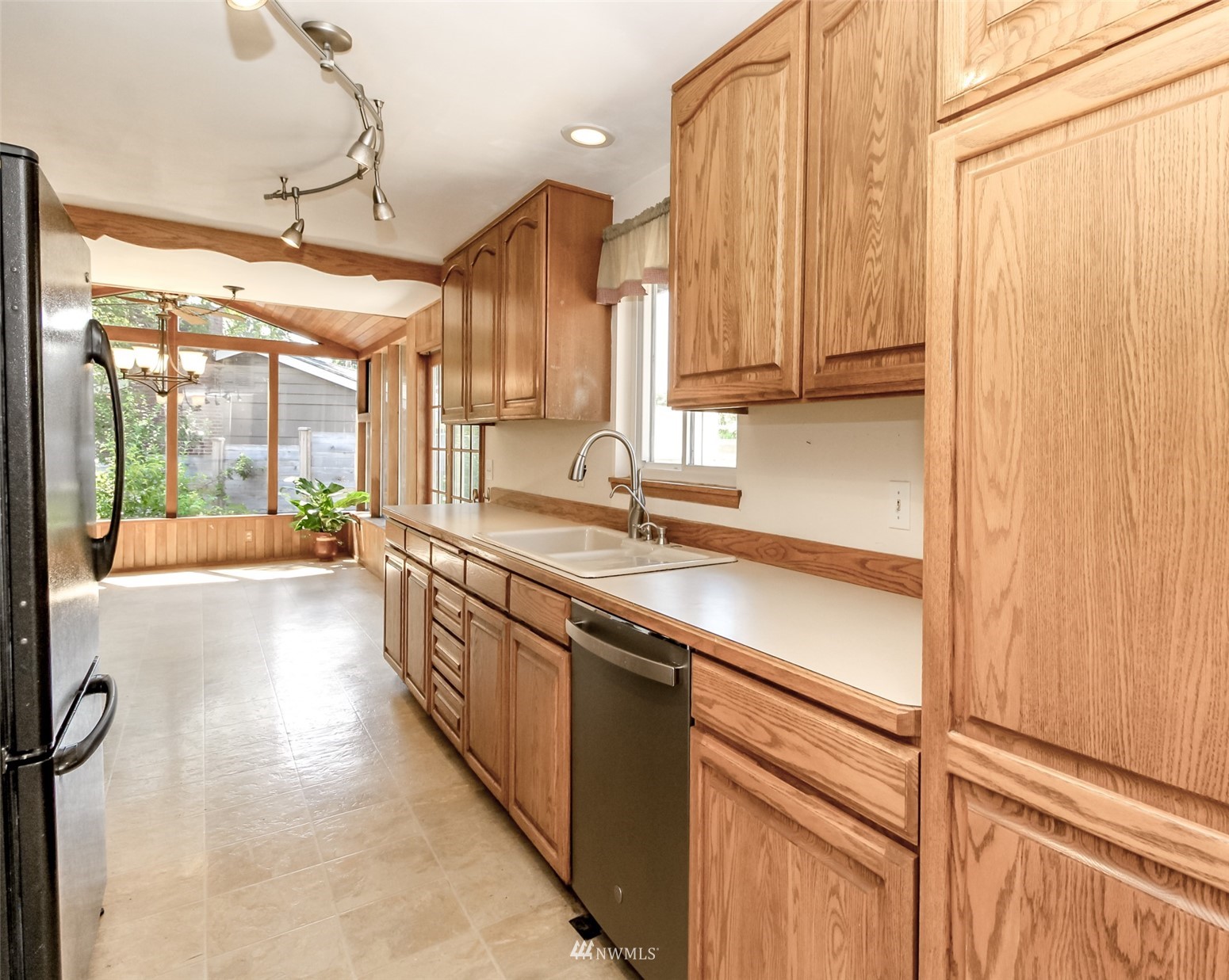12011 Southeast 157th Place Renton, WA 98058 - Photo 29 of 40 a large kitchen with kitchen island granite countertop a sink window and cabinets