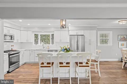 a kitchen with sink a microwave and cabinets