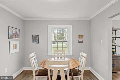 a view of an empty room with wooden floor and a fireplace