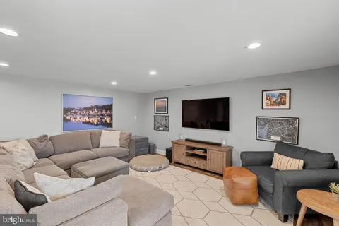 a living room with furniture a rug and wall painting