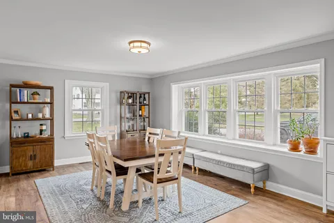 a living room with furniture a dining table and chairs with wooden floor