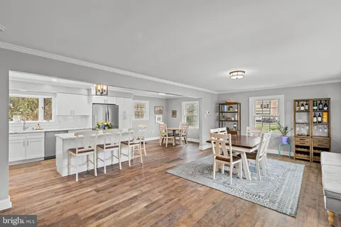 a view of a dining room with furniture a rug and wooden floor