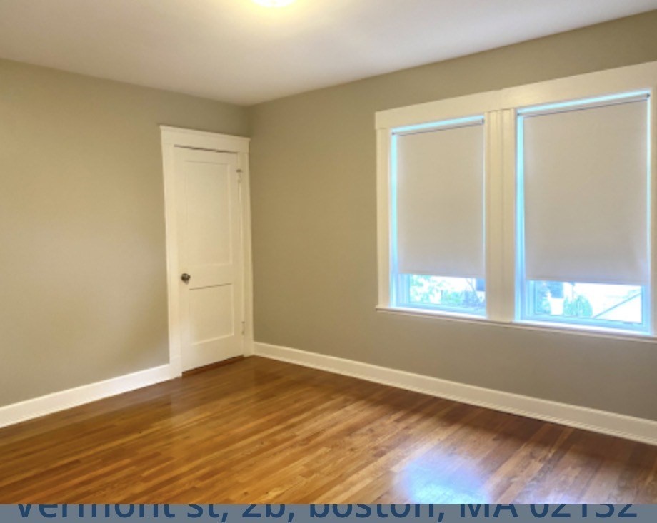 347 Vermont Street, Unit 2B Boston, MA 02132 - Photo 12 of 14 a view of an empty room with wooden floor and a window