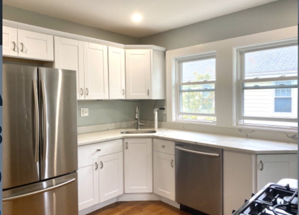 347 Vermont Street, Unit 2B Boston, MA 02132 - Photo 2 of 14 a kitchen with stainless steel appliances a refrigerator sink and cabinets