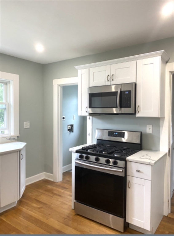 347 Vermont Street, Unit 2B Boston, MA 02132 - Photo 3 of 14 a kitchen with stainless steel appliances granite countertop a stove microwave and sink