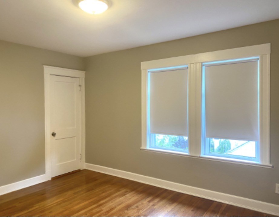 347 Vermont Street, Unit 2B Boston, MA 02132 - Photo 10 of 14 an empty room with wooden floor and windows