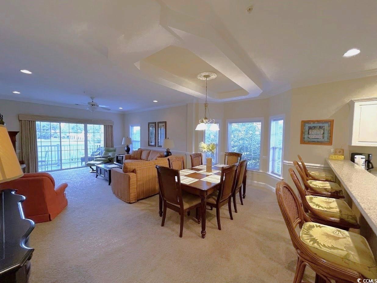 1008 Ray Costin Way, Unit 310 Murrells Inlet, SC 29576 - Photo 14 of 40 Carpeted dining area with ceiling fan, crown molding, and a healthy amount of sunlight