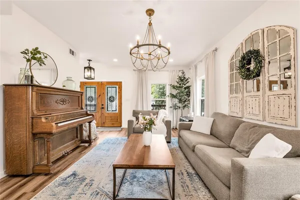 a living room with furniture a chandelier and a dining table