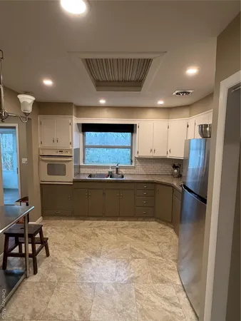 a kitchen with stainless steel appliances a refrigerator and a stove top oven