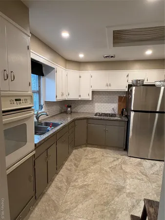 a kitchen with granite countertop a refrigerator sink and stove