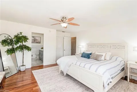 a bedroom with a large bed and a potted plant