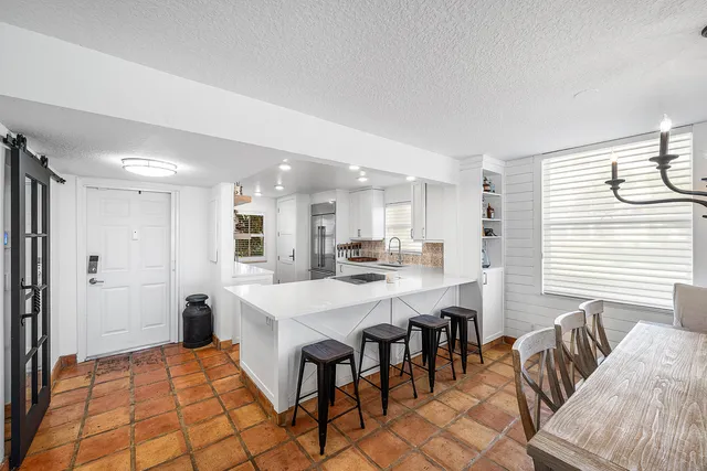 a large white kitchen with a table and chairs