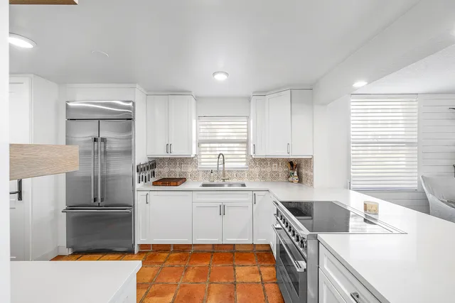 a kitchen with a sink a stove top oven and cabinets